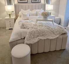 a large bed with white sheets and pillows on it's headboard in a bedroom