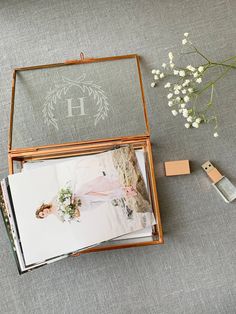 an open wooden box with wedding photos inside