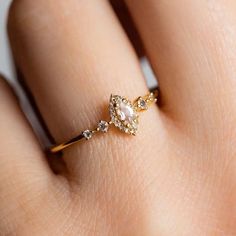 a woman's hand with a gold ring on it and a diamond in the middle