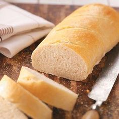 a loaf of bread sitting on top of a wooden cutting board next to sliced cheese