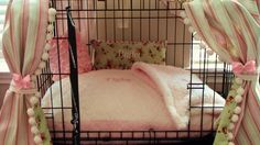 a cage with a bed and pillows in it