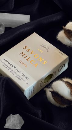 a book sitting on top of a black cloth next to some cotton balls and scissors