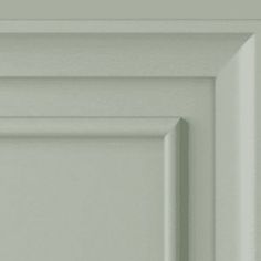 a close up view of the corner of a door with white paint and wood trim