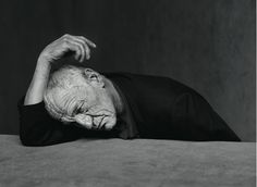 an old man laying on the ground with his head in his hands