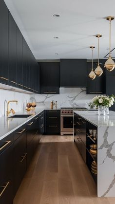 a large kitchen with marble counter tops and black cabinetry, along with wooden flooring