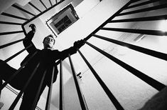 black and white photograph of two people standing on the top of a spiral stair case