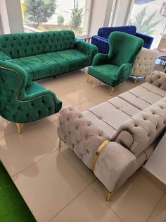 a living room filled with lots of green couches next to each other on top of a tile floor