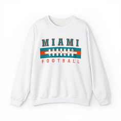 Are you ready for FOOTBALL SEASON?! And are you looking for a unique, retro design that differs from the generic team gear you find elsewhere online? This vintage styled, cute Miami Football sweatshirt is perfect to support your Miami Dolphin this football season! This crewneck is available in white, ash grey, sport grey, heather grey, sand, and black (pick one up for your husband/boyfriend/best friend/dad/mom etc too!) Sweatshirt details are below, and the models in the pictures are wearing lar Retro Tops For Football Season Streetwear, Retro Tops For Streetwear During Football Season, Collegiate Team-colored Sweatshirt With Logo, Collegiate Sweatshirt With Team Logo Print, White Tops For Football Season Streetwear, White Streetwear Tops For Football Season, Collegiate Graphic Print Sweatshirt For Fans, Collegiate Graphic Print Sweatshirt For Fan Merchandise, Retro Sports Fan Merchandise Tops