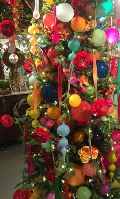 a brightly colored christmas tree decorated with ornaments