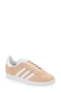 Initially designed as a training shoe for top athletes in 1991, adidas' iconic Gazelle sneaker has been refreshed with a sleek, narrower silhouette but retains the classic contrasting 3-Stripes and heel tab of the original, and is presented in throwback archival hues. Lace-up style Cushioned footbed Removable insole Leather or leather and synthetic upper/textile and synthetic or synthetic lining/synthetic sole Imported BP. Shoes Adidas Mid-top Sneakers For Spring, Urban Sneakers With Gum Sole For Spring, Spring Urban Sneakers With Gum Sole, Sporty Skate Shoes With Gum Sole For Spring, Athleisure Sneakers With Gum Sole For Spring, Leather Sneakers For Skateboarding In Spring, Spring Low-top Skate Shoes With Boost Midsole, Spring Low-top Skate Shoes With Gum Sole, Low-top Skate Shoes With Gum Sole For Spring