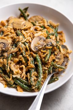 a white bowl filled with green beans and mushrooms