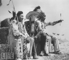 an old photo of two native americans sitting on a hay bale with their arms around each other