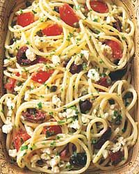 spaghetti with tomatoes, black olives, garlic and feta cheese in a wooden box