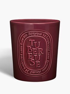 a red glass cup with the words tu ber jee on it's side