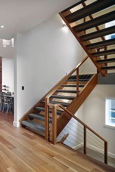 an open floor plan with wood floors and stairs