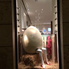 a mannequin sitting on top of a bale of hay in front of a store window