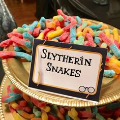 there is a sign that says, slytherin snakes on the top of a cake