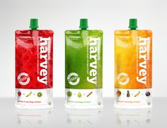 three different flavors of fruit juice in plastic bottles on a white surface with reflections from the floor