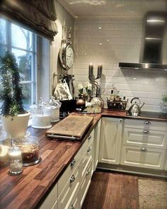 a kitchen with wooden counter tops and white cabinets