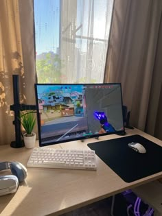 a computer monitor sitting on top of a wooden desk next to a keyboard and mouse