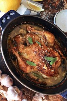 a chicken in a pan with garlic and lemons