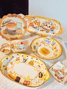 a table topped with plates and dishes covered in cartoon characters on it's sides