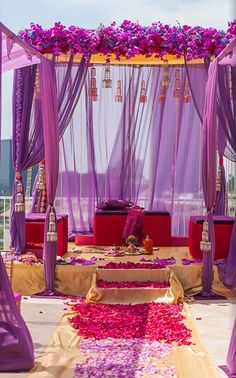 an outdoor wedding setup with purple drapes and flowers