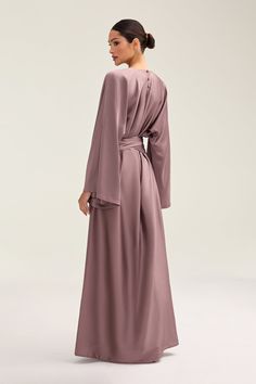 Indulge in luxury with the Batool Satin Maxi Dress. Its loose wide sleeves and lustrous satin fabric exude elegance, while the adjustable tie waist flatters your figure. Versatile design makes it perfect for Eid and beyond. Elevate your style with this exclusive piece. Model is 5'7 wearing size XS/58" Elegant V-neck Robe In Solid Color, Formal Wrap Maxi Dress With Tie Waist, Elegant Maxi Dress With Tie Waist And Kimono Sleeves, Elegant Robe With Tie Waist And Kimono Sleeves, Elegant Wrap Robe With Tie Waist, Elegant Wrap Maxi Dress With Draped Sleeves, Elegant Solid Color Long Sleeve Robe, Elegant Long Sleeve Solid Robe, Elegant Long Sleeve Robe