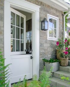 a white door and some flowers on the steps