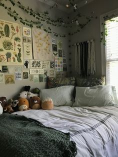 a bed with pillows and stuffed animals on top of it in front of a window