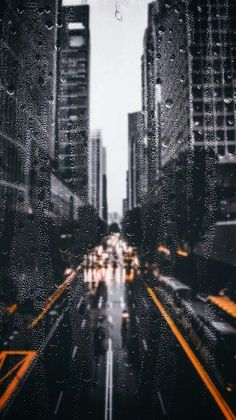 a city street filled with lots of traffic next to tall buildings and skyscrapers in the background