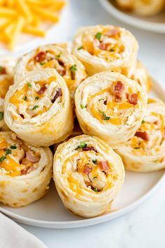 a white plate topped with rolls covered in cheese and bacon