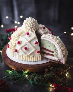 a cake that has been cut in half on a wooden platter with christmas lights around it