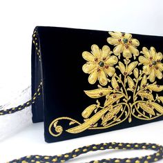 "Luxury black velvet evening clutch bag, expertly hand embroidered with gold flowers and embellished with genuine semi precious stones, to create an opulent, sophisticated 3D effect. Add an eye-catching pop of color, texture and sparkly bling to your overall party look. It is just the right size to hold your essentials for the night - phone, credit cards, money, keys and lipstick. The shoulder strap keeps your hands free for carrying a drink or holding a plate of food. Or twist the shoulder stra Hand Embellished Black Evening Bag, Black Hand Embellished Evening Bag, Elegant Hand Embellished Black Bag, Elegant Black Hand-embellished Bag, Elegant Black Hand-embellished Clutch, Elegant Black Hand Embellished Clutch, Luxury Hand Embellished Black Evening Bag, Luxury Hand-embellished Black Evening Bag, Luxury Black Hand Embellished Evening Bag