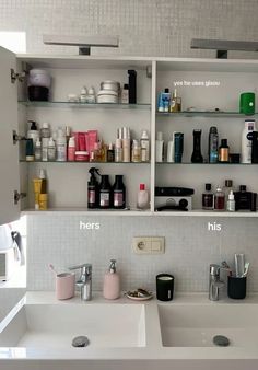 two sinks in a bathroom with shelves on the wall above them and various personal care items