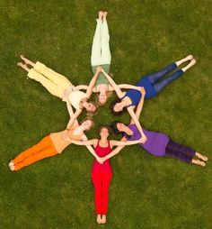 six women are standing in a circle on the grass with their hands together and one woman is holding her head up