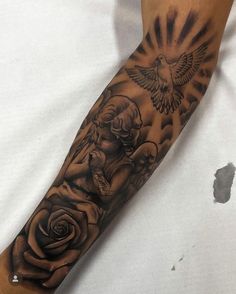 a person with a tattoo on their arm holding a rose and a bird in the sky