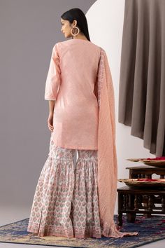 Rose pink short kurta with polka dot hand block print and lace embroidered placket, neckline. Paired with floral print gharara and dupatta.
Component: 3
Pattern: Printed
Type Of Work: Polka Dots, Floral
Neckline: Round
Sleeve Type: Three quarter
Fabric: Kurta and Gharara - Cotton Cambric, Dupatta - Cotton Mulmul
Color: Pink
Other Details: 
Front button detailing
Rounded hem
Side tassel tie-up
Contrast dupatta
Tiered gharara
Occasion: Sangeet - Aza Fashions Contrast Dupatta, Pink Kurta, Short Kurta, Pink Polka Dots, Pink Shorts, Set For Women, Pink Print, Rose Pink, Aza Fashion