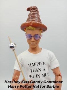 there is a toy with a hat and sunglasses on it's head holding a stick