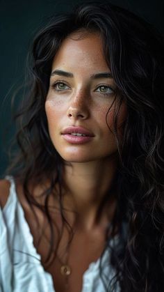 a woman with long dark hair is posing for the camera, wearing a white shirt