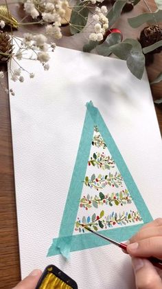 someone is painting a christmas tree on a piece of paper