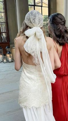 two women dressed in white and red are walking down the street with their backs to each other