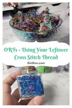 a hand holding a glass jar filled with colorful crochet stitch thread