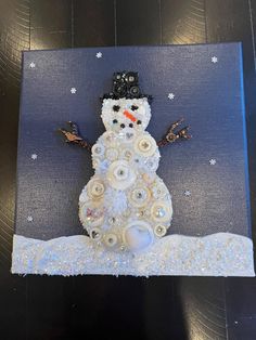 a snowman made out of buttons and fabric