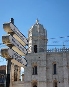 a street sign in front of an old building with a clock tower on the top