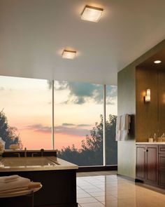 a bathroom with large windows overlooking the sunset