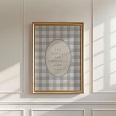 a white and blue checkered wall with a gold framed poster hanging on the wall