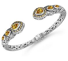 a silver bracelet with yellow stones on it