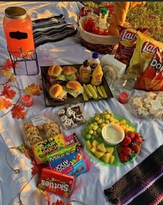 a picnic table with snacks, fruit and other food items on it in the fall