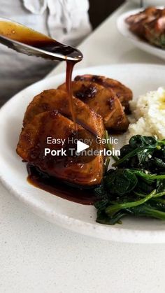 a plate with meat, rice and spinach on it is being drizzled with sauce